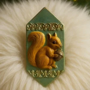 Decorative wax tablet with embossed squirrel holding an acorn, set on soft white faux fur with vintage green background and ornate detailing