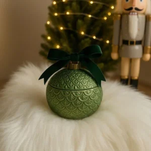 Green Christmas ornament candle jar with embossed scallop pattern and dark green velvet bow
