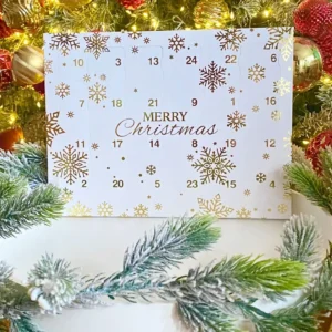 Luxury advent calendar with 24 wax melts in holiday fragrances, displayed under Christmas tree with lights and ornaments — perfect gift for candle and scent lovers