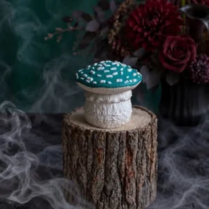 Handmade scented candle shaped like a Stropharia aeruginosa mushroom with a turquoise cap and white spots.
